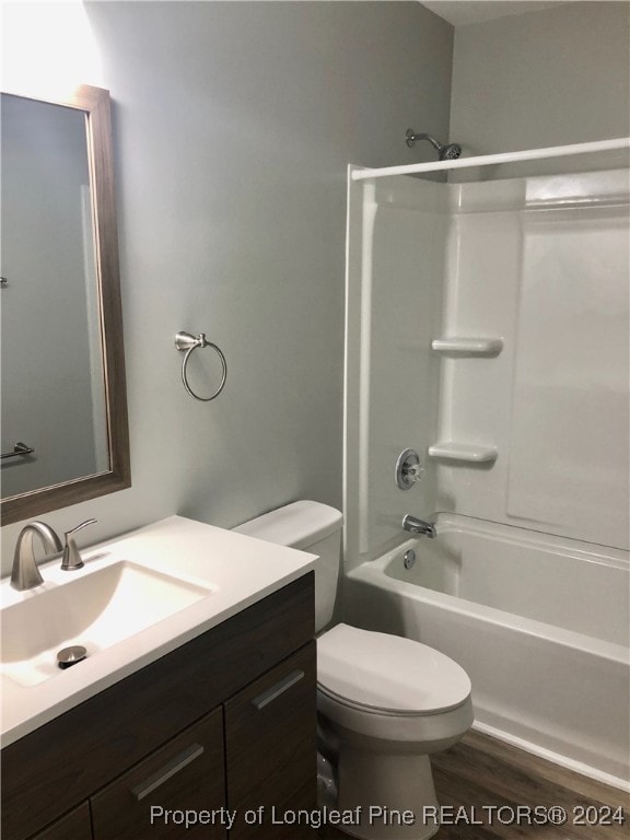 full bathroom featuring toilet, hardwood / wood-style floors, vanity, and tub / shower combination