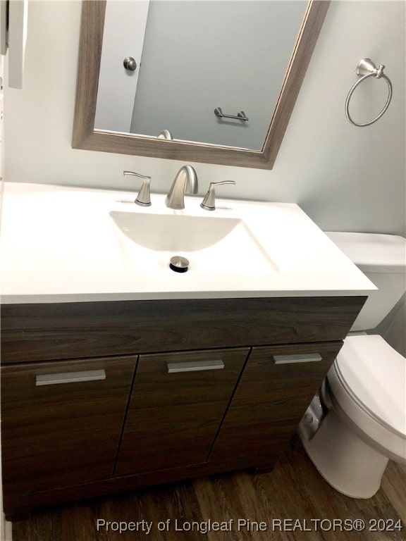 bathroom featuring vanity, hardwood / wood-style flooring, and toilet