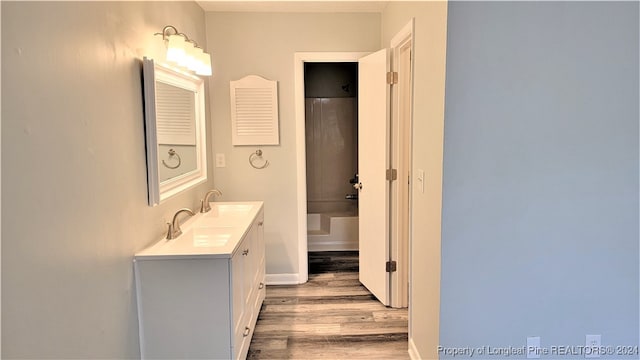 bathroom with shower / bathing tub combination, vanity, and hardwood / wood-style flooring