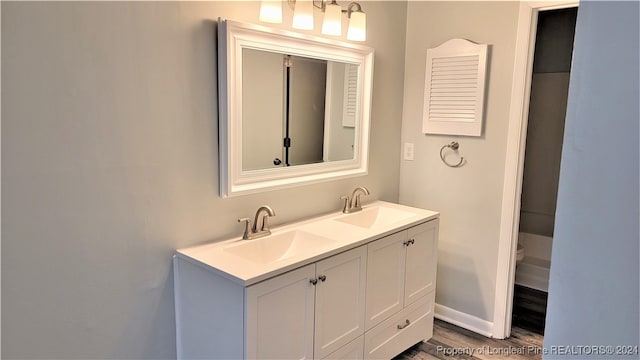 bathroom with hardwood / wood-style floors, vanity, and toilet