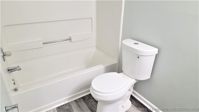 bathroom featuring hardwood / wood-style flooring,  shower combination, and toilet