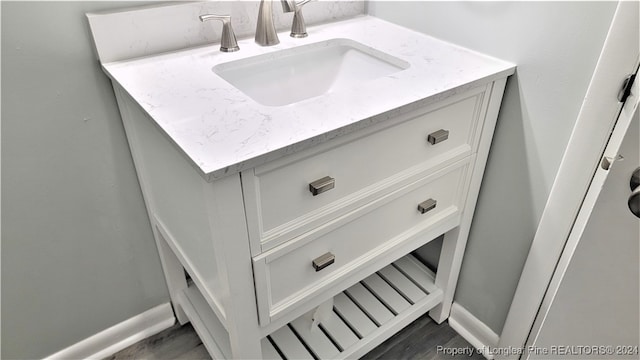 interior details featuring hardwood / wood-style floors and vanity