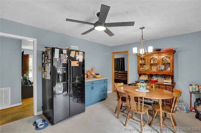 kitchen with pendant lighting, black refrigerator with ice dispenser, ceiling fan with notable chandelier, a textured ceiling, and light hardwood / wood-style floors