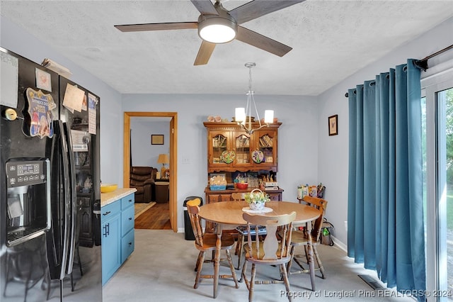 dining area with ceiling fan with notable chandelier and a textured ceiling