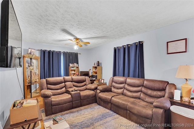 living room with carpet flooring, a textured ceiling, and ceiling fan