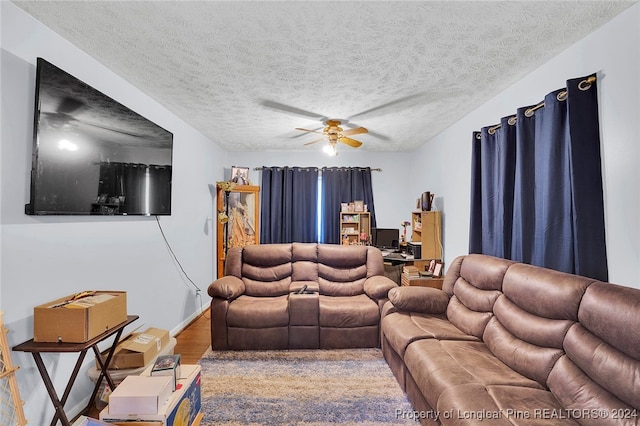 living room featuring ceiling fan, a textured ceiling, and hardwood / wood-style flooring