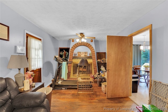 living room with wood-type flooring, a textured ceiling, a wealth of natural light, and ceiling fan