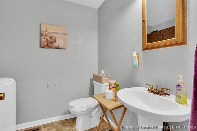 bathroom featuring sink, a textured ceiling, and toilet