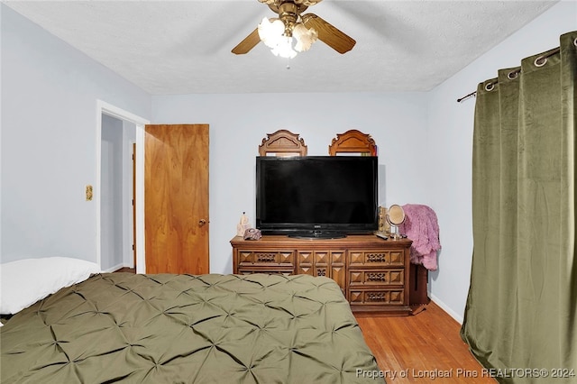 bedroom featuring a textured ceiling, light wood-type flooring, and ceiling fan