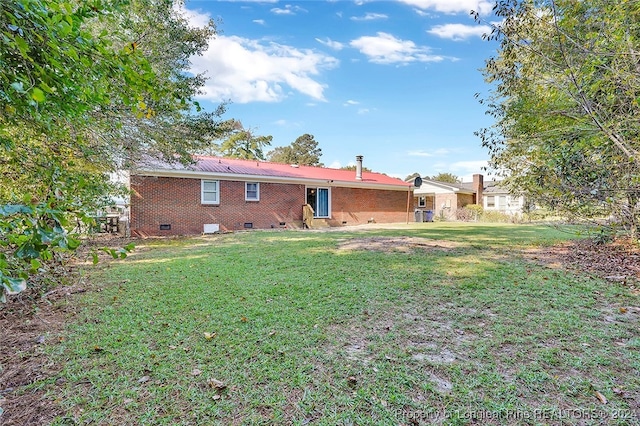 rear view of property with a lawn