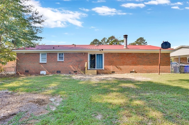 rear view of house featuring a lawn