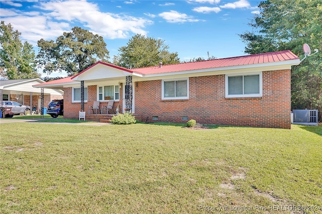 ranch-style home with a front yard, a carport, cooling unit, and covered porch