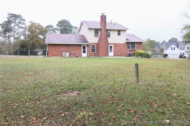 rear view of house featuring a yard