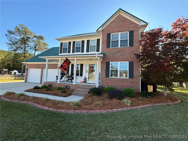 view of front facade featuring covered porch, a garage, and a front yard