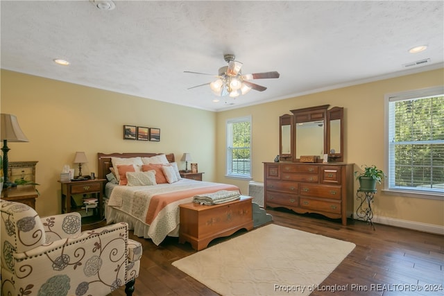 bedroom with a textured ceiling, dark hardwood / wood-style floors, ceiling fan, and crown molding