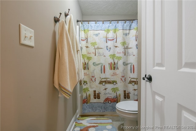 bathroom featuring tile patterned floors, a shower with shower curtain, a textured ceiling, and toilet