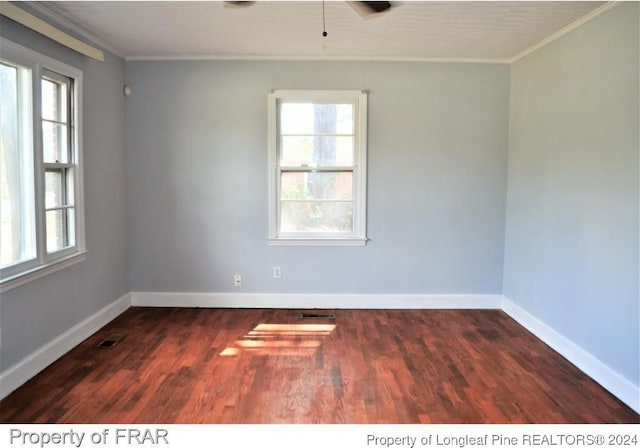 spare room featuring ceiling fan, dark hardwood / wood-style flooring, ornamental molding, and a wealth of natural light