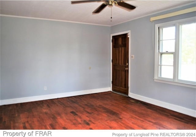 empty room with ornamental molding, ceiling fan, and dark wood-type flooring