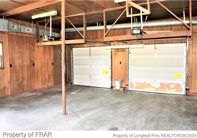 garage featuring wooden walls and a garage door opener