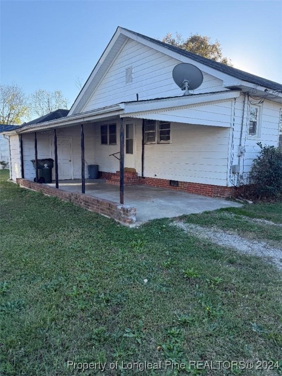 back of property with a patio area and a yard