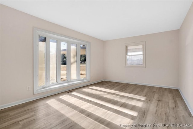 spare room with a wealth of natural light and light hardwood / wood-style flooring