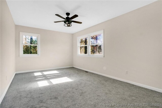 carpeted empty room featuring ceiling fan and a healthy amount of sunlight