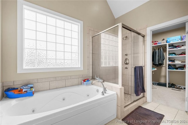 bathroom featuring tile patterned flooring, vaulted ceiling, plenty of natural light, and independent shower and bath