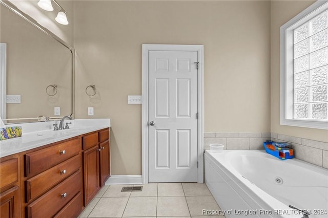 bathroom featuring tile patterned floors, a tub to relax in, and vanity