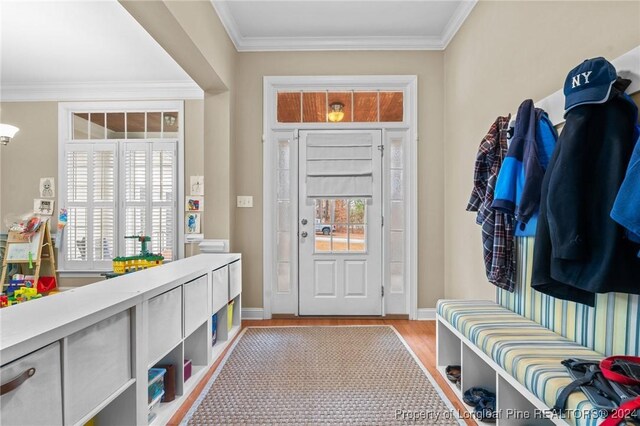 mudroom featuring light wood-type flooring and crown molding