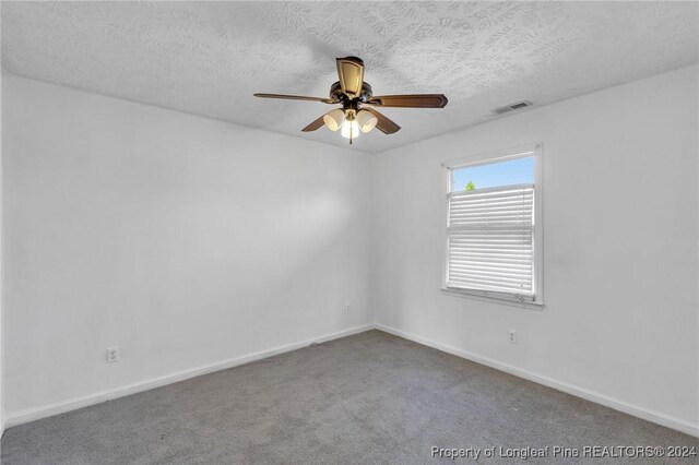 empty room featuring carpet, ceiling fan, and a textured ceiling