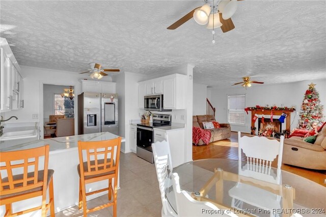 dining space featuring a textured ceiling, light hardwood / wood-style floors, and sink