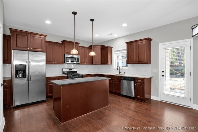 kitchen featuring sink, a center island, hanging light fixtures, plenty of natural light, and appliances with stainless steel finishes