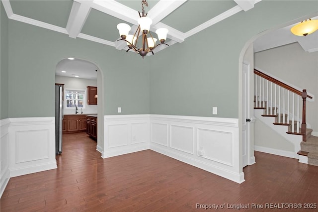 unfurnished dining area featuring a chandelier, dark hardwood / wood-style floors, crown molding, and sink