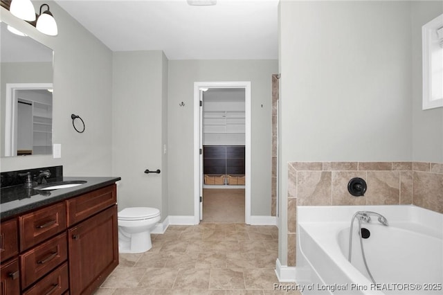 bathroom with a bathtub, vanity, and toilet