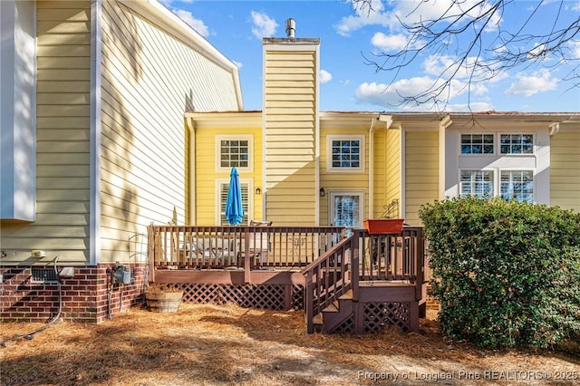 rear view of property featuring a wooden deck