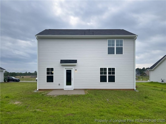 rear view of property featuring a lawn and a patio