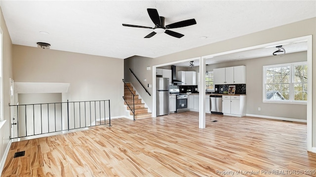 unfurnished living room featuring light hardwood / wood-style flooring and ceiling fan