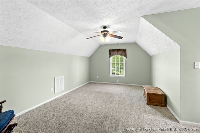 bonus room with lofted ceiling, ceiling fan, light carpet, and a textured ceiling