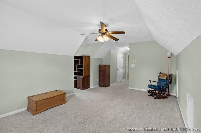 bonus room featuring lofted ceiling, light carpet, a textured ceiling, and ceiling fan