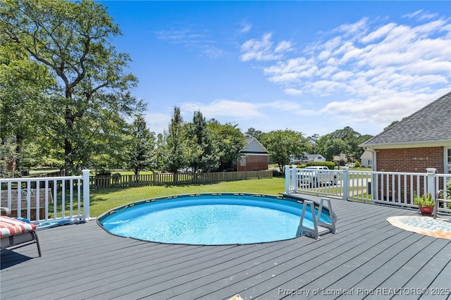 view of swimming pool with a yard and a deck