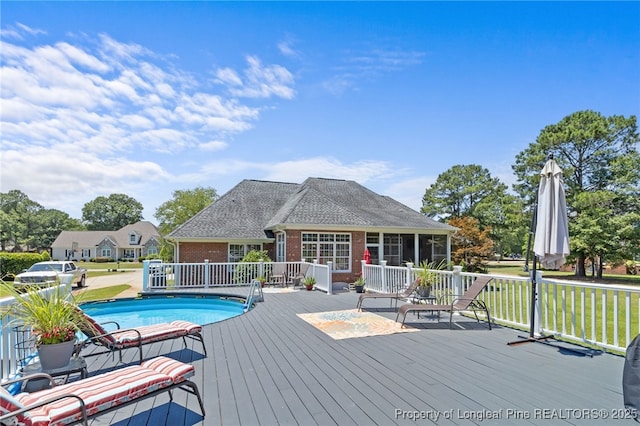 view of swimming pool featuring a wooden deck and a yard