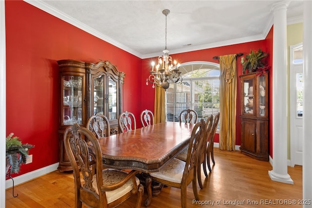 dining area with an inviting chandelier, crown molding, hardwood / wood-style floors, and decorative columns