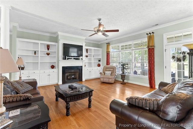 living room featuring crown molding, ceiling fan, light hardwood / wood-style floors, and a textured ceiling