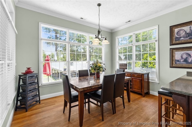 dining space featuring wood-type flooring, crown molding, and a textured ceiling