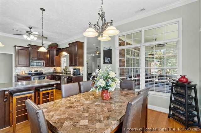 dining area with sink, ornamental molding, ceiling fan, light hardwood / wood-style floors, and a textured ceiling