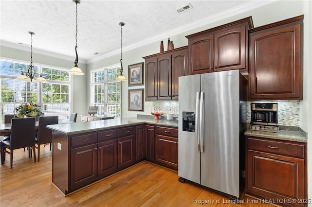 kitchen featuring tasteful backsplash, stainless steel fridge, decorative light fixtures, and light hardwood / wood-style floors