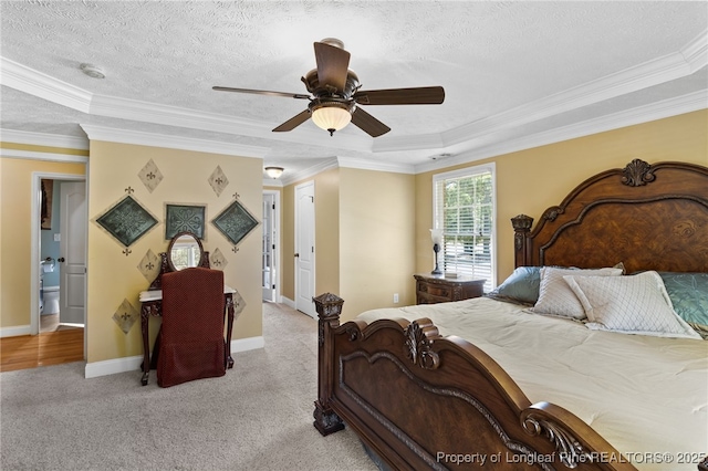 bedroom featuring ceiling fan, ornamental molding, a raised ceiling, and light colored carpet