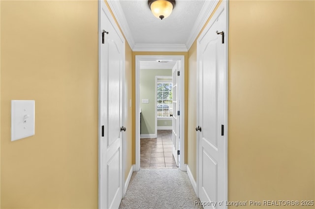 hall with crown molding, light colored carpet, and a textured ceiling