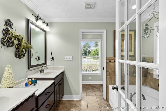 bathroom with crown molding, tile patterned flooring, vanity, a textured ceiling, and a tub