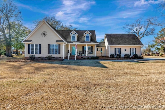 new england style home featuring a front yard and a porch